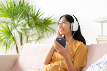 Asian teenager listen to music on smartphone with headphone enjoy. 