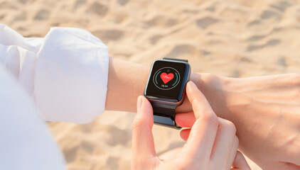 Hand wearing a smartwatch and checking active lifestyle and using fitness tracker outdoor on the...