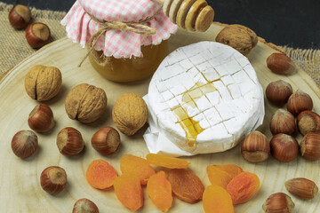 Delicious camembert cheese and honey, close-up. Side view