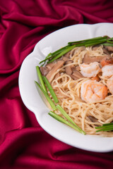 wok fried fu Zhou braised ee fu noodle bee hoon longevity noodle mee with seafood mushroom prawn egg meat and vegetables on wood table asian chinese halal food menu for restaurant