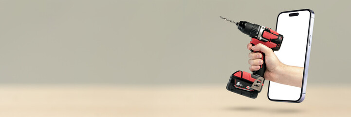 Buying power tools online. Online shopping banner. A screwdriver in hand protrudes from a mobile...