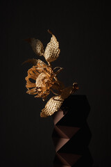 Flower made of straw on a dark background. The flower is illuminated by the sun. Small depth of field. 