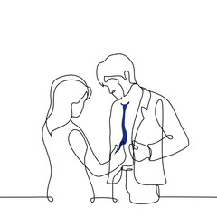 woman corrects a man in a business suit tie, helps to dress, evaluates a tie - one line drawing vector. concept of helping to dress, stylist