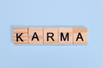 Karma word from wooden letters on blue background