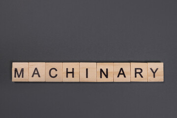 machinary word from wooden blocks on gray background