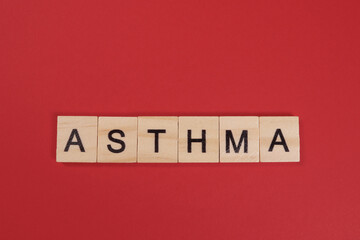 Word Asthma from wooden letters on red background