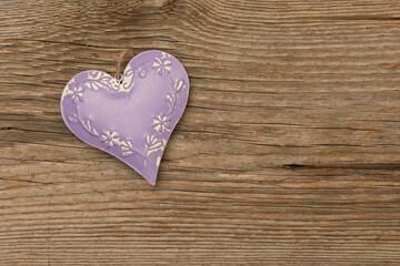 purple metal heart on rustic brown wooden background with free space for text