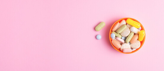 Pharmaceutical web banner with pills and dietary supplements on pink background.