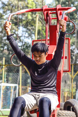 Active young man exercising on chest press machine at outdoor gym.