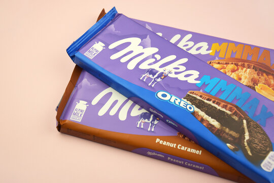 Chocolate brand Milka with Oreo flavor and caramel on a soft pink background.