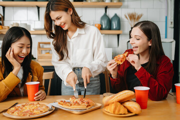 Group of friends making fun at home party.They sitting on desk in living room and eating pizza. happy