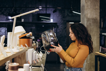 a woman in an electronics store chooses a air dryer.