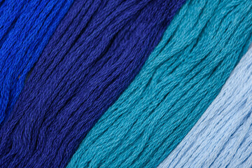 Bawełniane nici w różnych odcieniach koloru niebieskiego w zbliżeniu makro ułożone na ukos