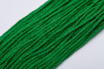 Zielone sznurki leżące na ukos na białym tle w zbliżeniu makro