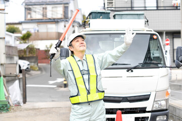 交通誘導をするシニアの男性ガードマン