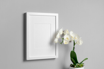 White picture frame mockup with orchid flower, blank poster frame mockup