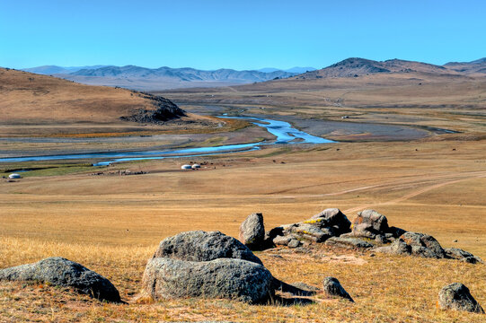 Flußlandschaft mit mäandrierendem Flußlauf in der Steppe der Mongolei, Zentralasien mit vereinzelten Jurten von Nomaden