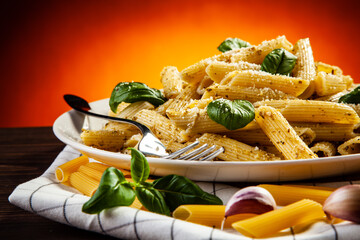 Noodles with parmesan cheese and basil served on wooden table
