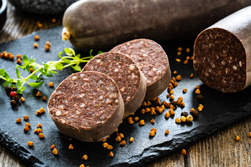 Raw buckwheat pudding on black stone cutting board on wooden table
