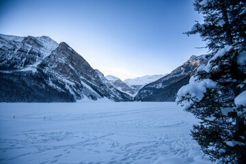 Chilling view of a snow-covered field against a mountainous landscape background