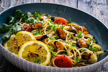 Noodles with clams on wooden table
