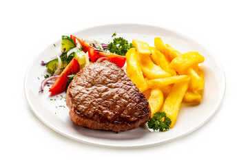 Fried beef sirloin with French fries and vegetables on white background
