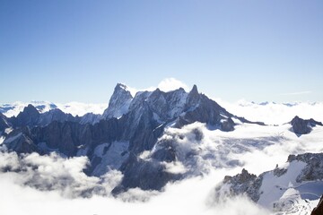 Fototapeta na wymiar Aerial view of snowcap Grandes Jorasses mountain peak above the white clouds