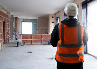 Foreman in building under construction. Worker back to camera. Apartment renovation master. Man in...