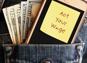 Cash money and smartphone in jeans pocket with handwritten stick note ACT YOUR WAGE, viral  workplace trend which employees respectfully decline tasks that  not paid or financially compensated for