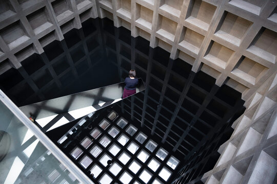 HOBART, TASMANIA, AUSTRALIA - MARCH 02 2023: Woman stands in an art installation with sump oil and steel in the MONA Museum of Old and New Art in Hobart, Tasmania. The oil fills the whole room