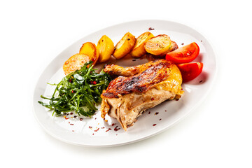 Barbecued chicken thigh with fried potatoes, arugula and tomatoes on white background