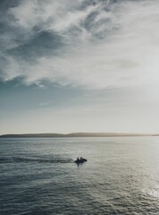 Vertical of people riding a water scooter in the sea on a beautiful day