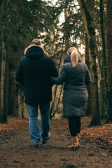 Fototapeta premium Vertical shot of a couple walking in the park