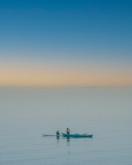 Naklejka premium View of two boats in the blue sea under the yellow sky.