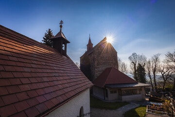 Aufgehende Sonne hinter kleiner romantischer Kirche