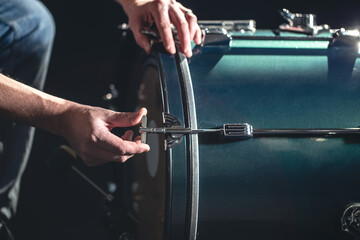 Bass drum and drummer, musical instrument on black background.