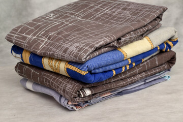 A stack of bed linen on a white background.