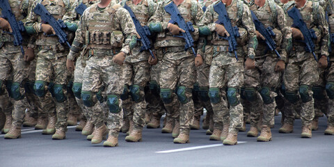 Military soldiers march in a parade with weapons. Pixel uniform. Soldier legs. War background. Boots of special forces and infantry. Men go power