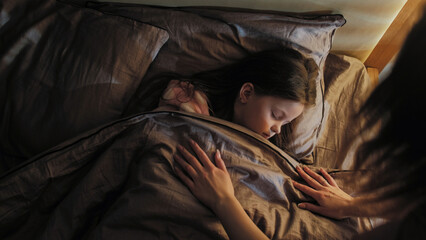 Sleeping child mother care. Night rest. Woman covering peaceful calm daughter with blanket lying in...