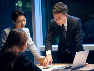 asian project team working late together meeting in office