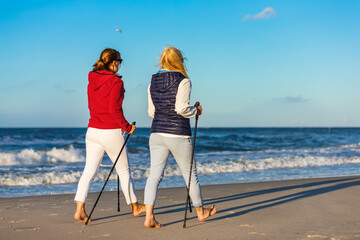 Nordic walking - two women training on beach
