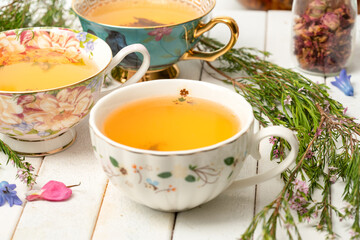 Tea cups with herbal tea and flowers