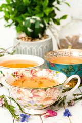 Tea cups with herbal tea and flowers