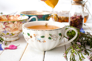 Tea cups with herbal tea and flowers
