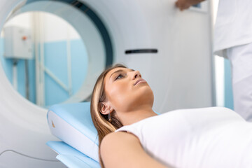 Female Patient Lying on a CT or PET or MRI Scan Bed, Moving Inside the Machine While it Scans Her Brain and Vital Parameters.