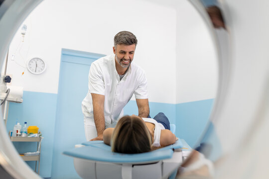 Hospital Radiographer With Female Patient Operating CT Scanner. Female patient undergoing MRI - Magnetic resonance imaging in Hospital. Medical Equipment and Health Care.