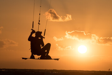 Kiten, kite surfing at sunset in the baltic sea
