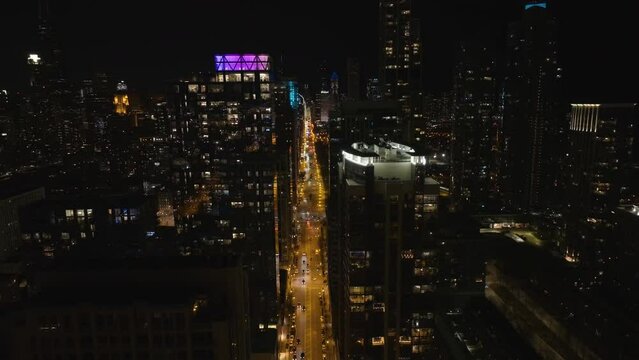 Aerial view overlooking Michigan avenue, nighttime in South Loop, Chicago, USA - reverse, drone shot