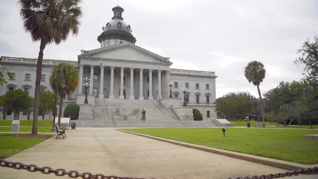 South Carolina State House government building landmark on a cloudy day with palm trees out front in slow motion