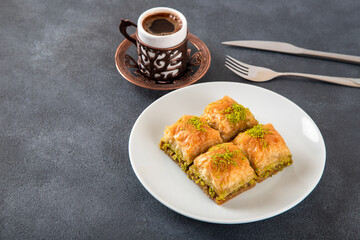 Traditional pistachio baklava with Turkish coffee on black background,top view